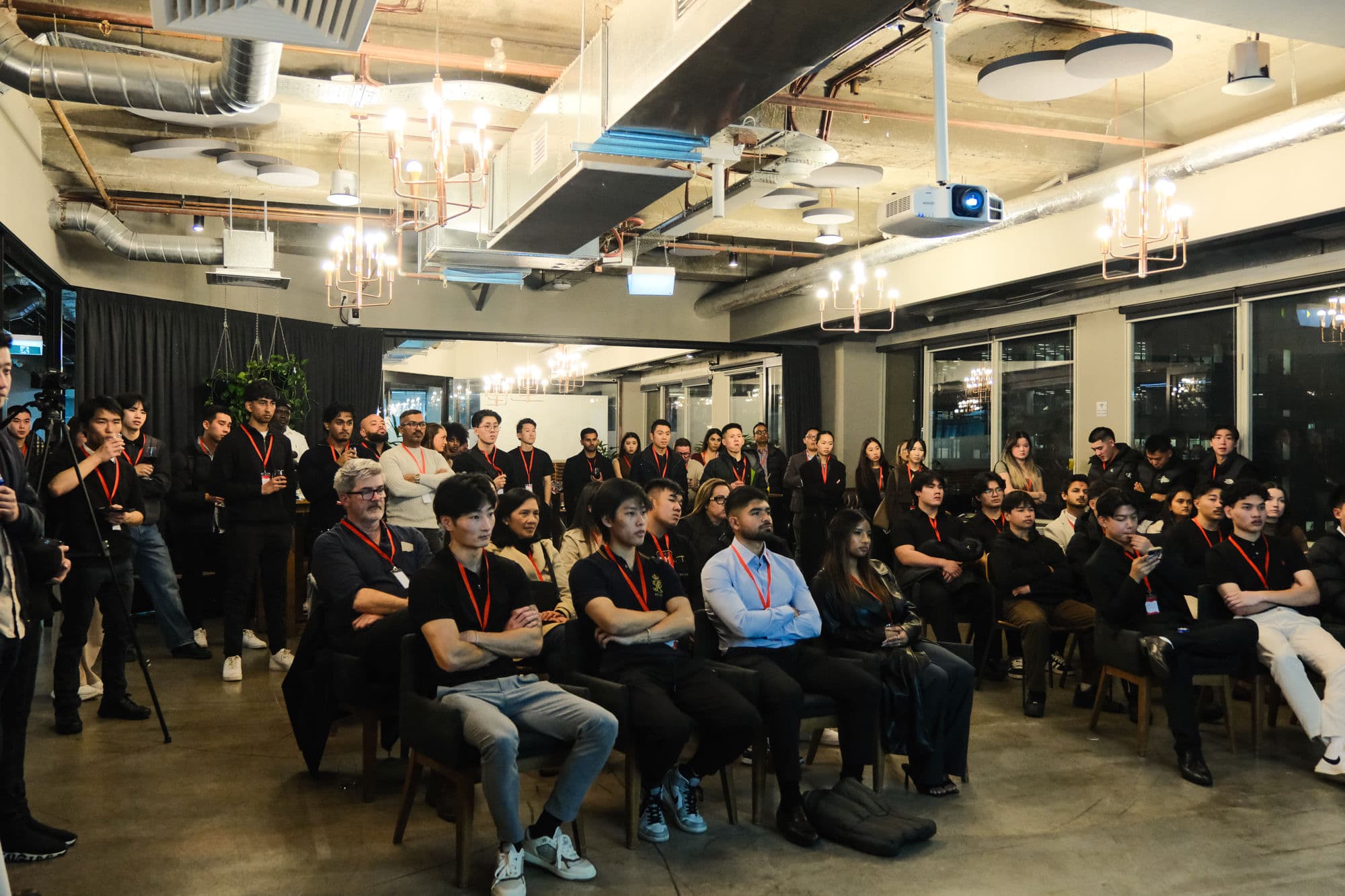 A full room of BNB Success members at a previous community event, wearing red lanyards