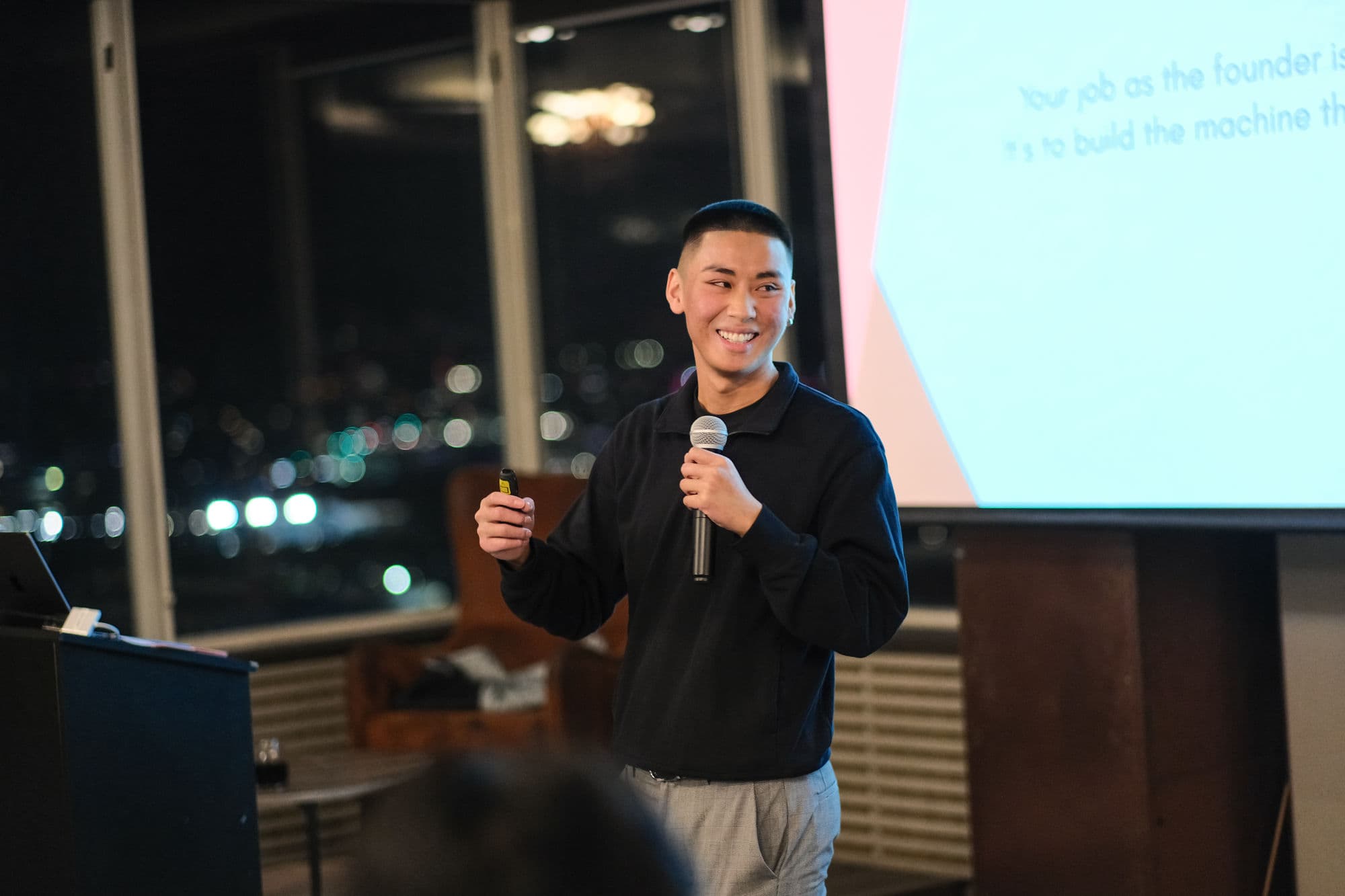 A BNB Success founder presenting on stage with a microphone at a previous event